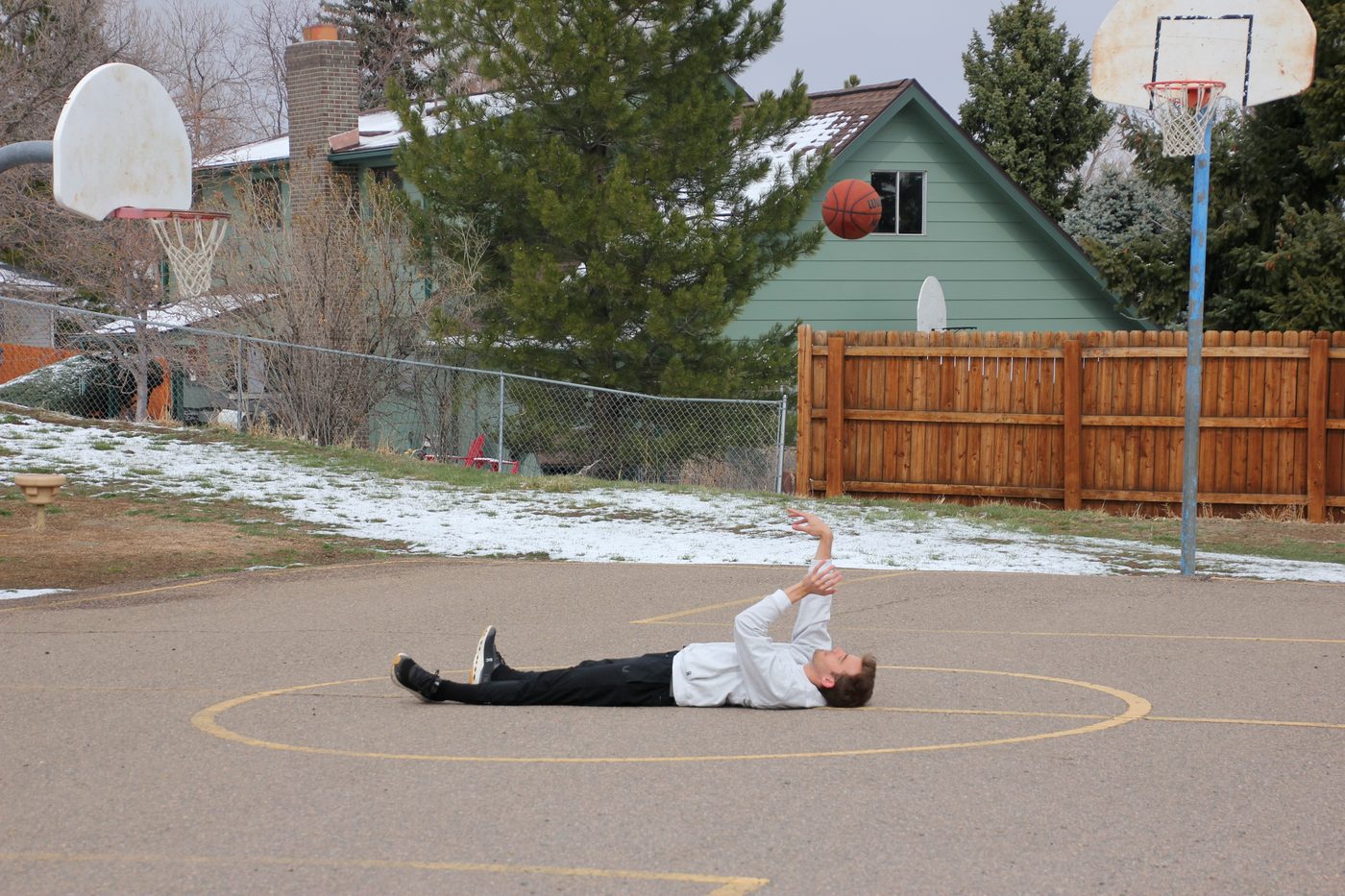 Kyle Wisniewski lying on an outdoor court with a basketball, Golden, Colorado, 2025